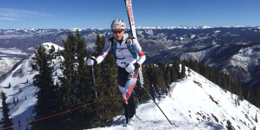 Travis Macy summiting a snowy peak. 