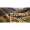 Team Injinji athlete Phil Shin running on a single track trail on a moutainside.