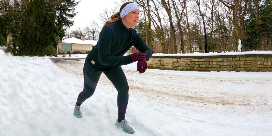 Kati Keenan in running position on the bank of a snowy running path.