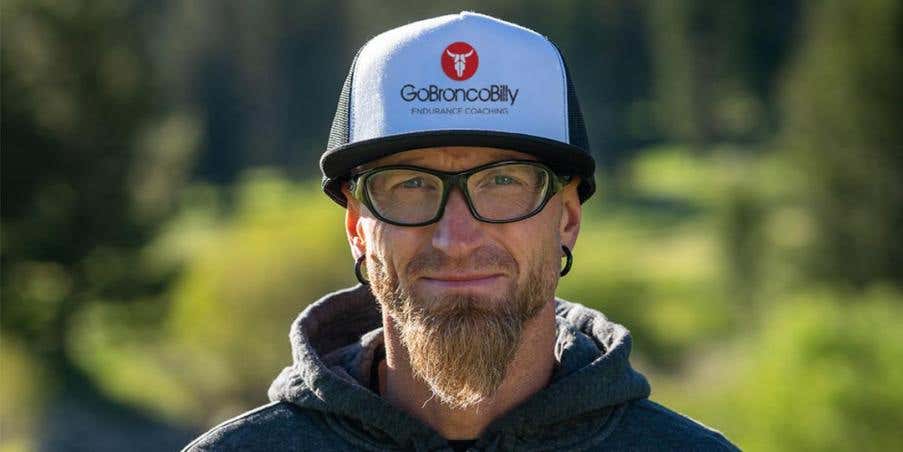 Portrait of Coach Jeff Browning standing outdoors wearing a GoBroncoBilly Ultra Endurance trucker hat.