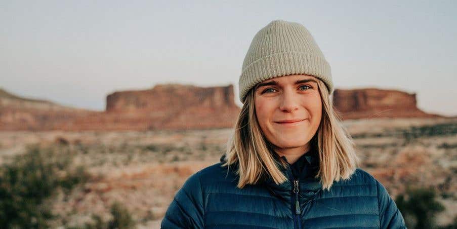 Kika McFarlane standing in front of desert mesas in Moab, Utah.