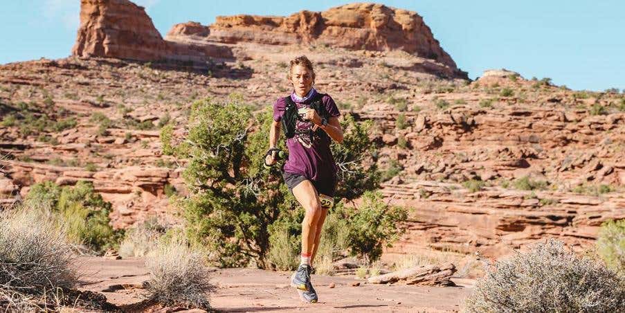 Anita Ortiz in purple t-shirt running on the mountain road