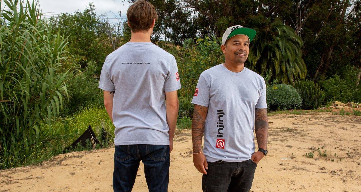 Two models side by side facing opposite directions on a trail wearing the Men's Injinji Performance Grey T-Shirt