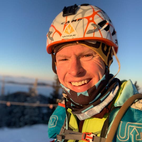 Smiling Travis Macy in hiking equipment