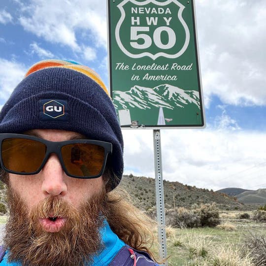 Mike in Nevada reaching The Loneliest Road in America sign on Highway 50. 