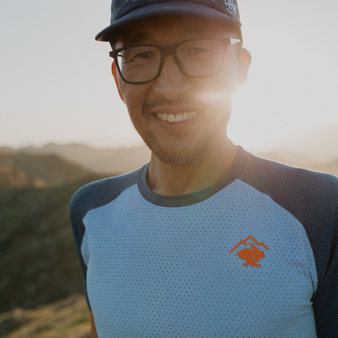 Team Injinji athlete Phil Shin smiling outside with the late afternoon sun shining behind him.