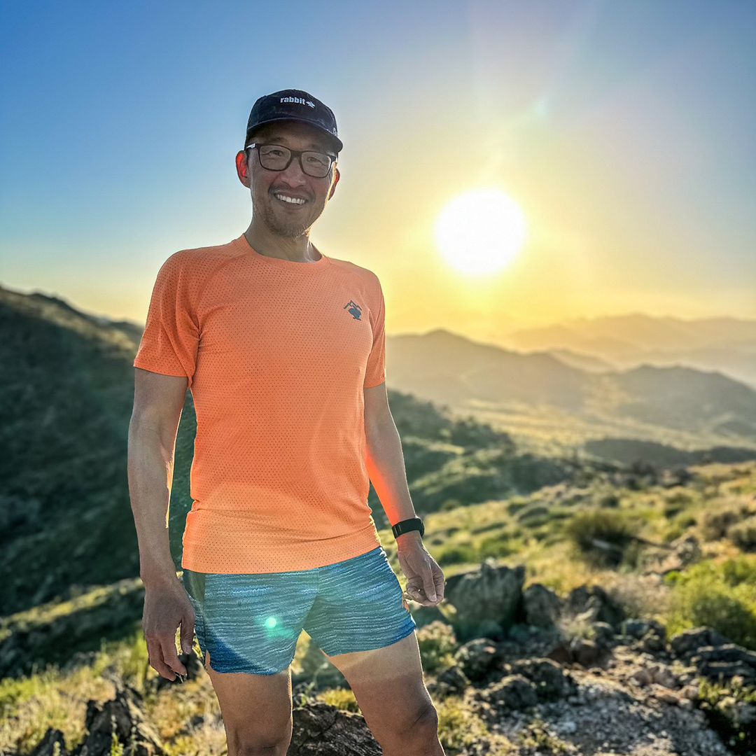 Team Injinji athlete Phil Shin standing outside with late afternoon sun shining behind him.