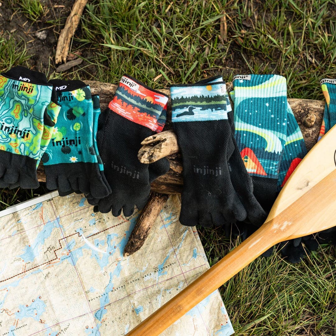 Toesocks from Injinji's Artist Designed Boundary Water Collections with a map and an oar.
