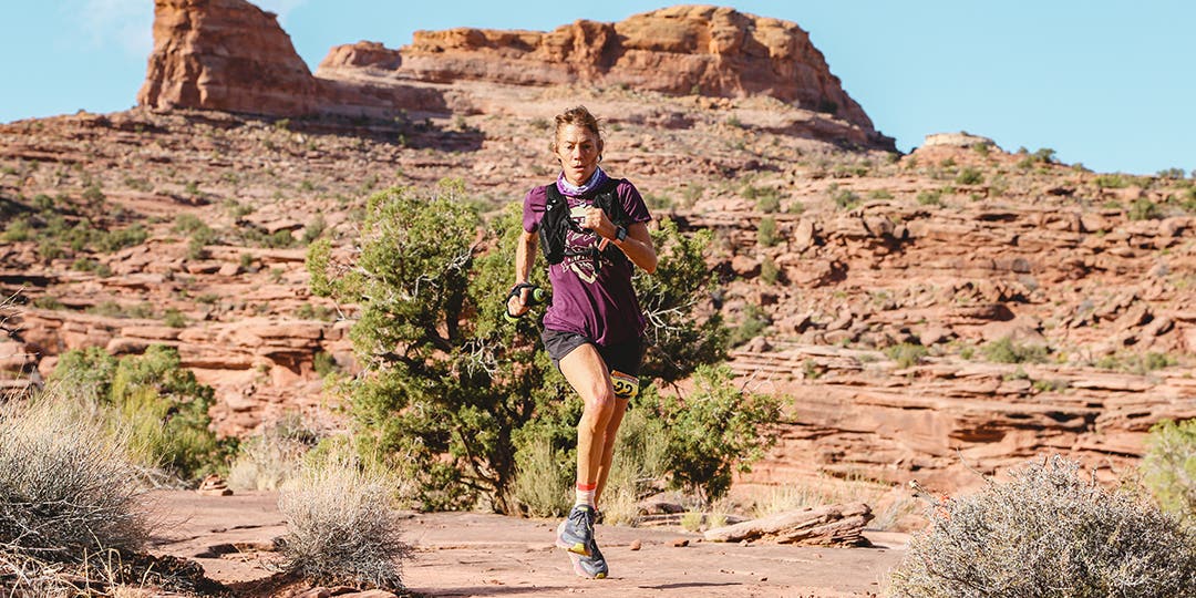 Anita Ortiz in purple t-shirt running on the mountain road