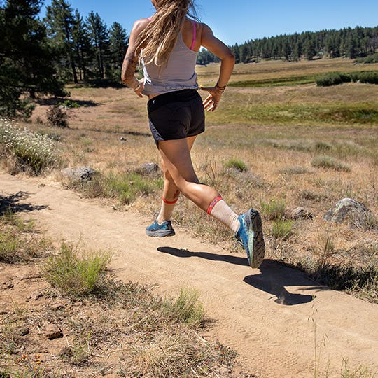 Woman Running On A Trail