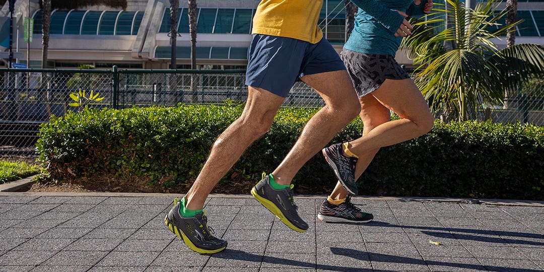 Two People Running Side-by-Side In The City