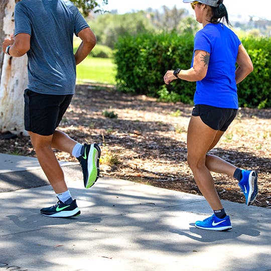 Man and woman running in bright sneakers seen from the side