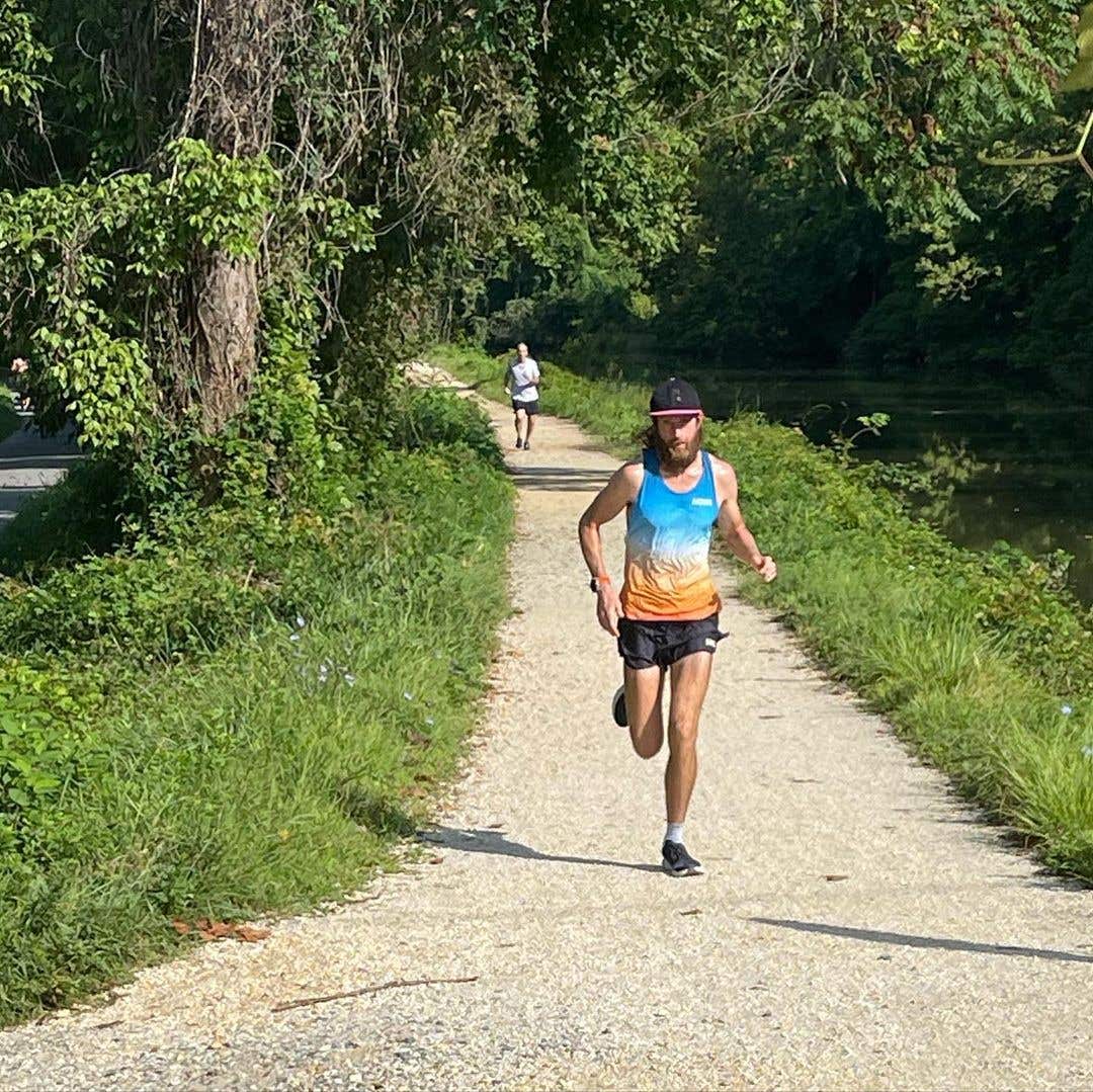 Mike Wardian running hard down a gravel path during a race.