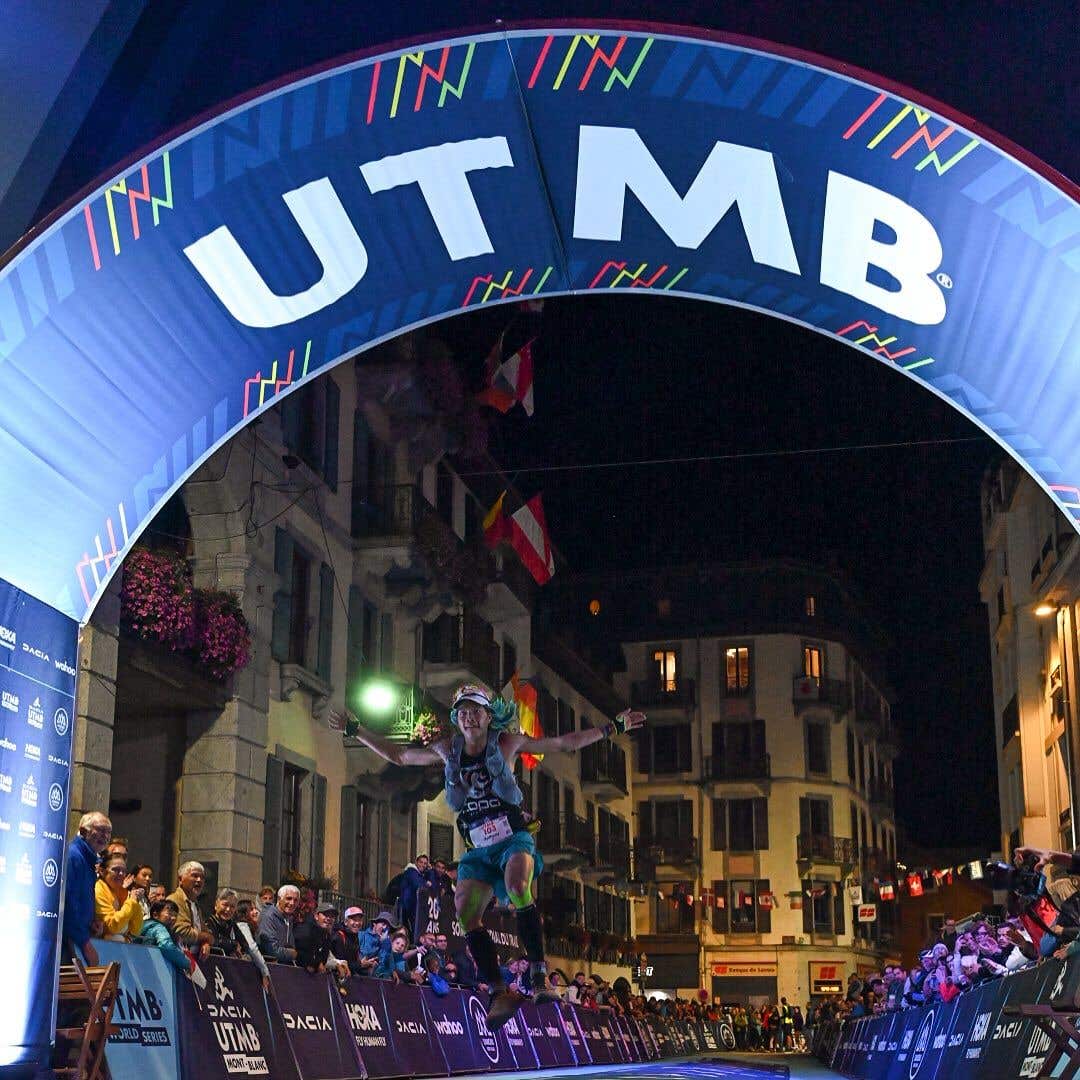 Team Injinji athlete Anthony Lee jumping at the finish line of Ultra Trail du Mont Blanc.