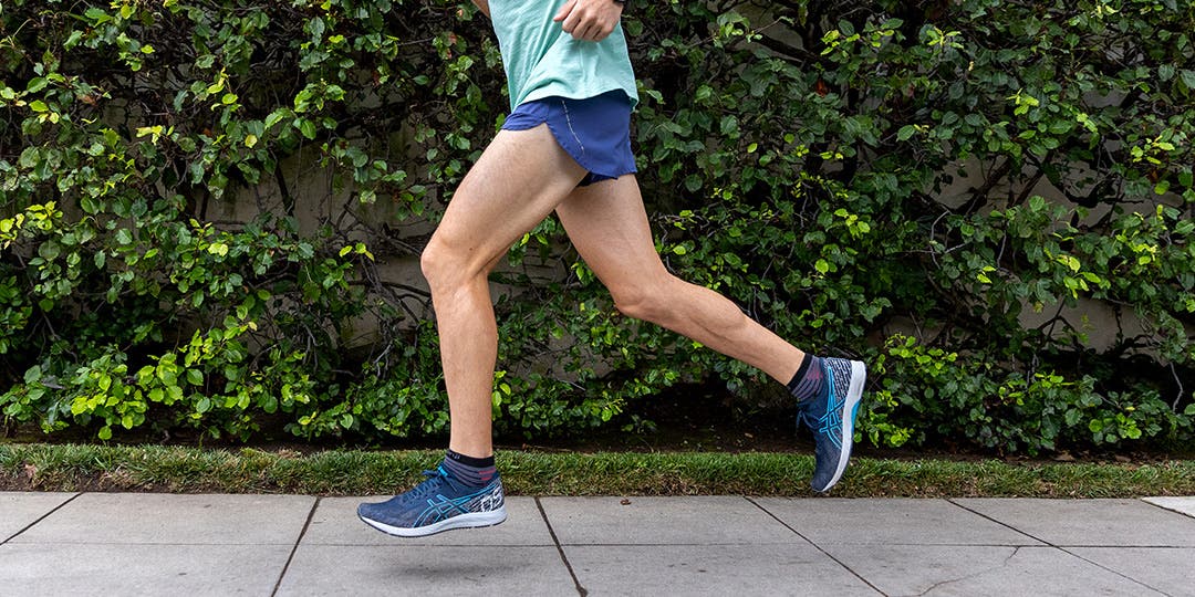 A man running on the sidewalk wearing Injinji socks.