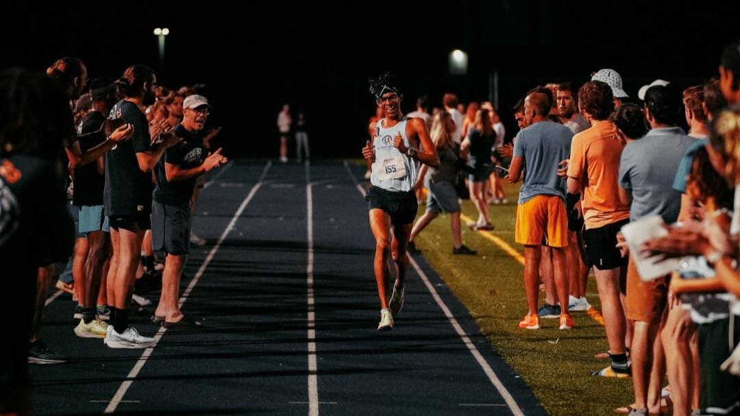 Team Injinji athlete Cris Gutierrez running toward the finish line of a road race.