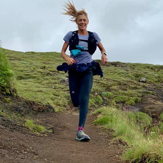 Anita Ortiz happily running surrounded by green landscape