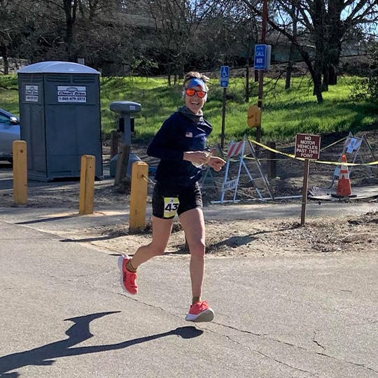 Smiling Meghan Canfield running in the city environment