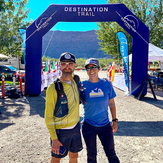 Jeff Browning posing with Team Manager Isabella Janovick in front of the Destination Trails finish line. 