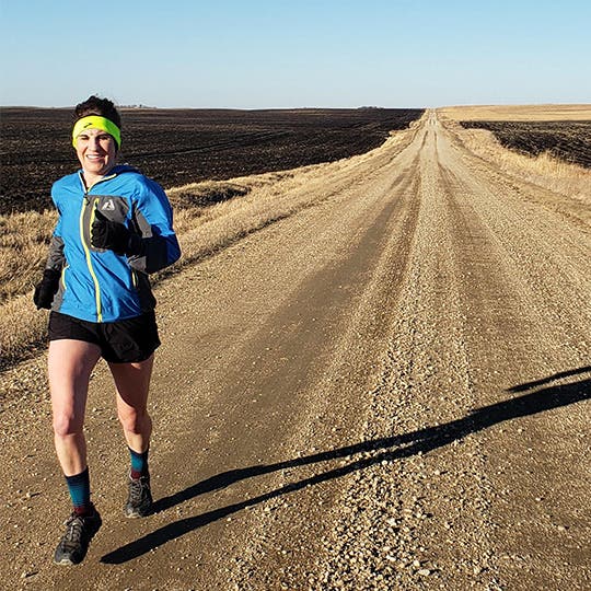 Coach Jill Becker running on the desertous road