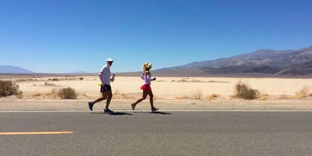 Two Team Injinji athletes running on an asphalt road at the Badwater 135 ultramarathon.