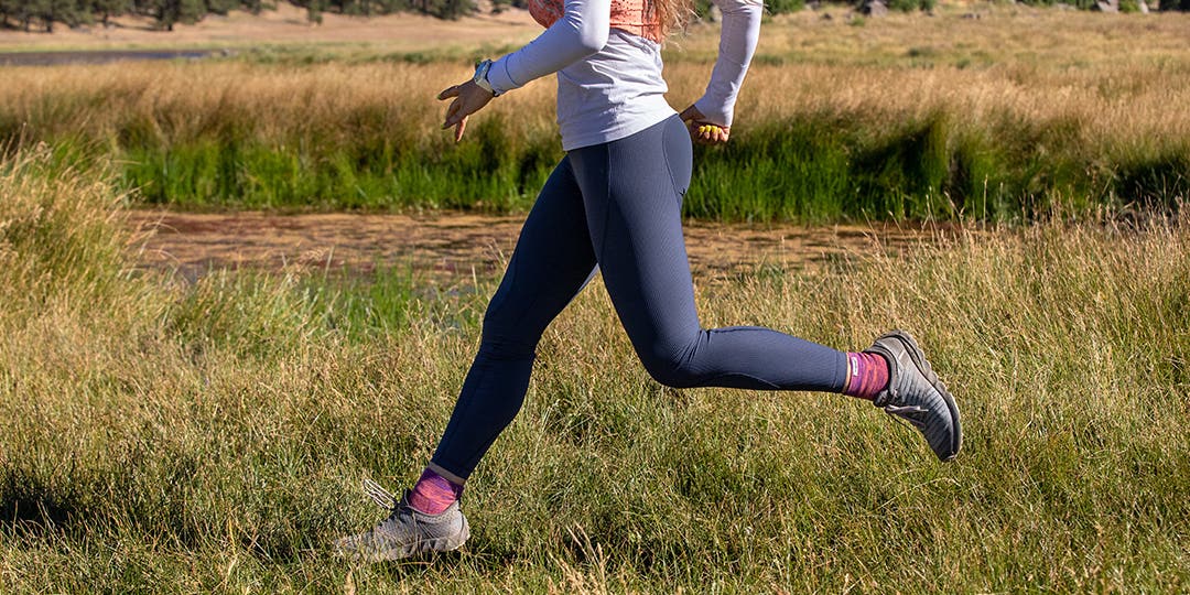 Legs of a woman wearing sport leggings and burgundy socks