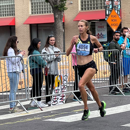Meriah Earle racing at the San Diego Half Marathon while fans and bystanders watch. Meriah Earle racing at the San Diego Half Marathon while fans and bystanders watch.