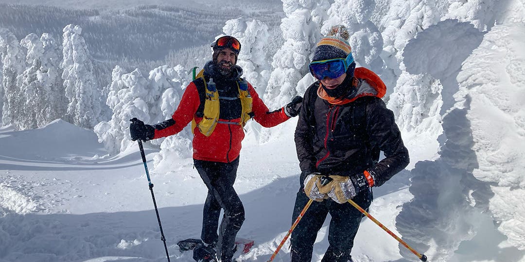 Peter Mortimer and a friend both wearing full snowgear, snowshoes, and poles while climbing up Humprey's Peak covered in deep snow.