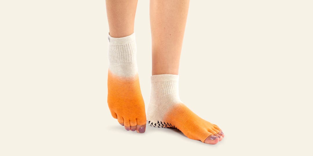 Closeup of someone pointing their toes wearing Injinji Grip Toeless Mini-Crew socks.