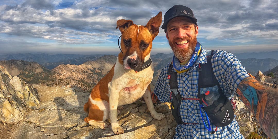 Garrick Arends taking a selfie with his dog Olly at the top of a summit.