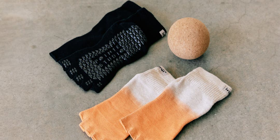 Two pairs of Injinji Grip Toeless Mini-crew socks and a cork ball for barre.
