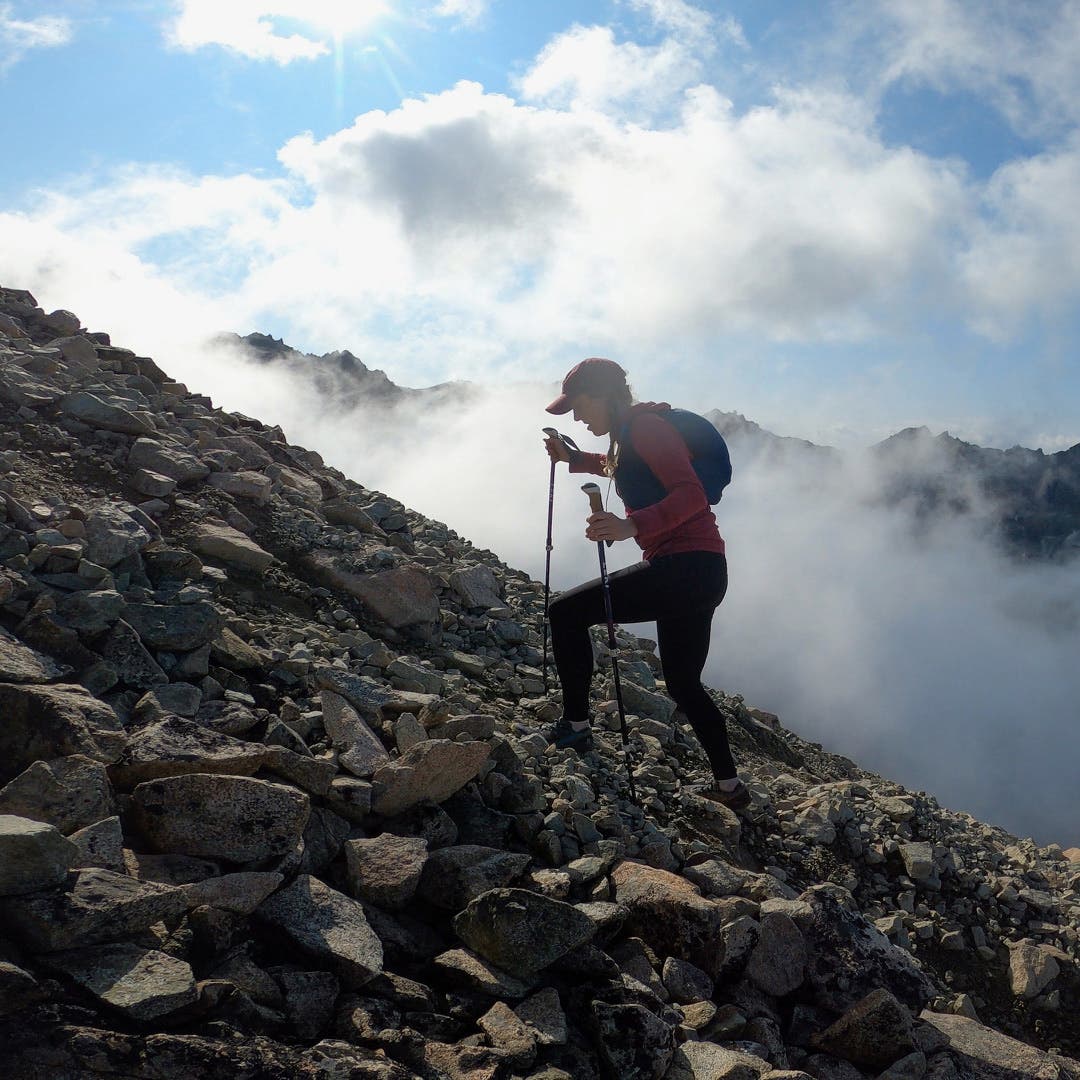Ultra Runner Caroline Himbert treking up a rocky mountain.