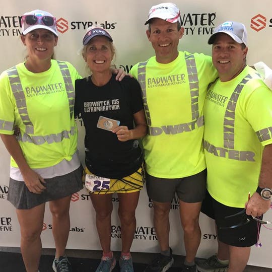 Four participants of "Badwater 135" race standing side by side and smiling