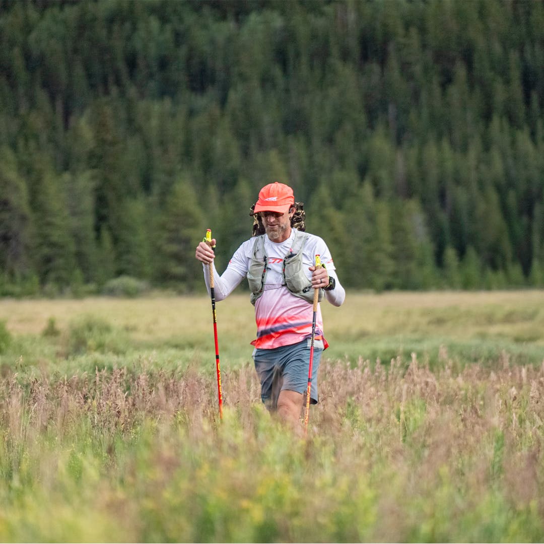 Jeff Browning running through a meadow on his FKT attempt.