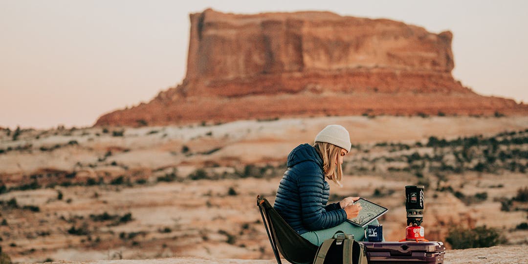 Artist Designed Canyons Collection artist Kika MacFarlane drawing at her camping spot in the desert of Moab, Utah.