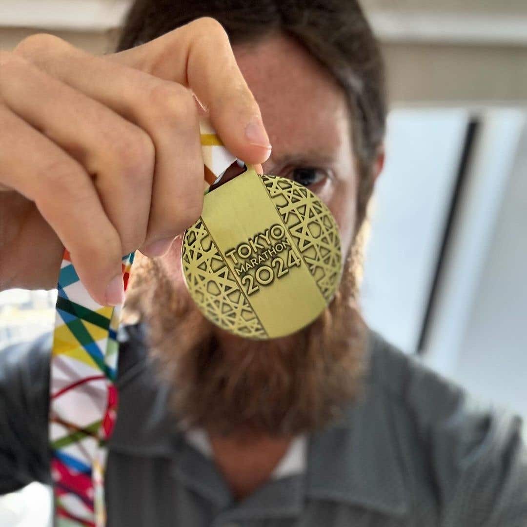 Team Injinji Athlete Mike Wardian holding up his Tokyo Marathon medal.