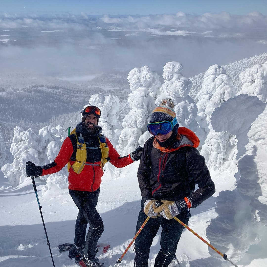 Peter Mortimer and a friend both wearing full snowgear, snowshoes, and poles while climbing up Humprey's Peak covered in deep snow.