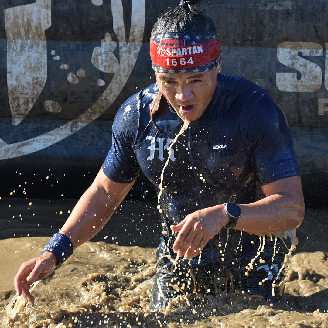 Justin Nucum emerging from freezing cold water during an obstacle course race.