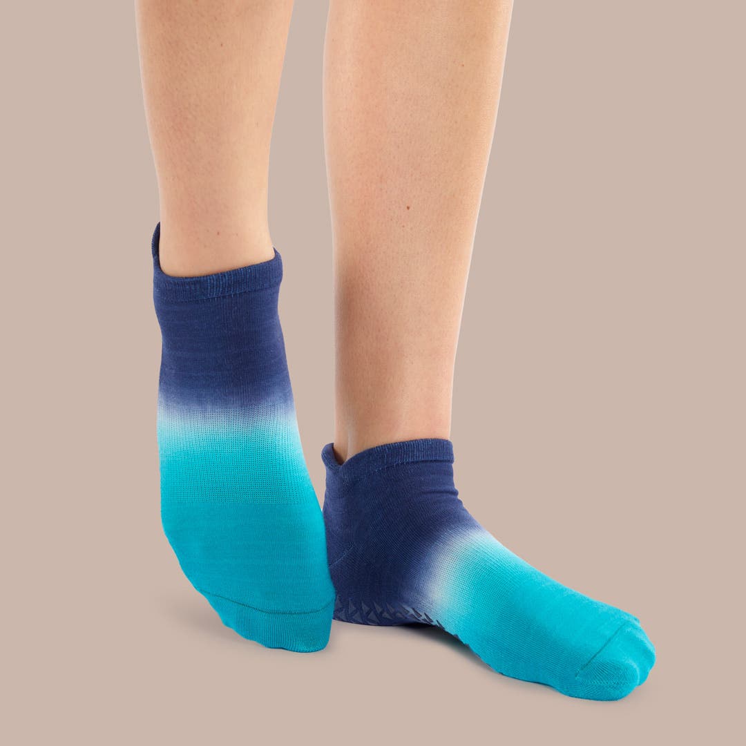 Closeup of someone pointing their toes wearing Injinji Grip Full Foot No-Show socks.