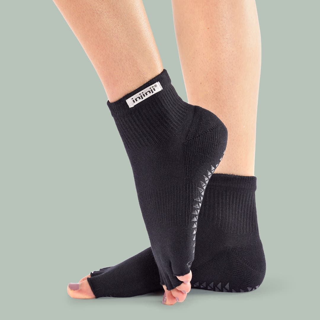 Closeup of someone pointing their foot wearing Injinji Grip Toeless Mini-Crew socks.