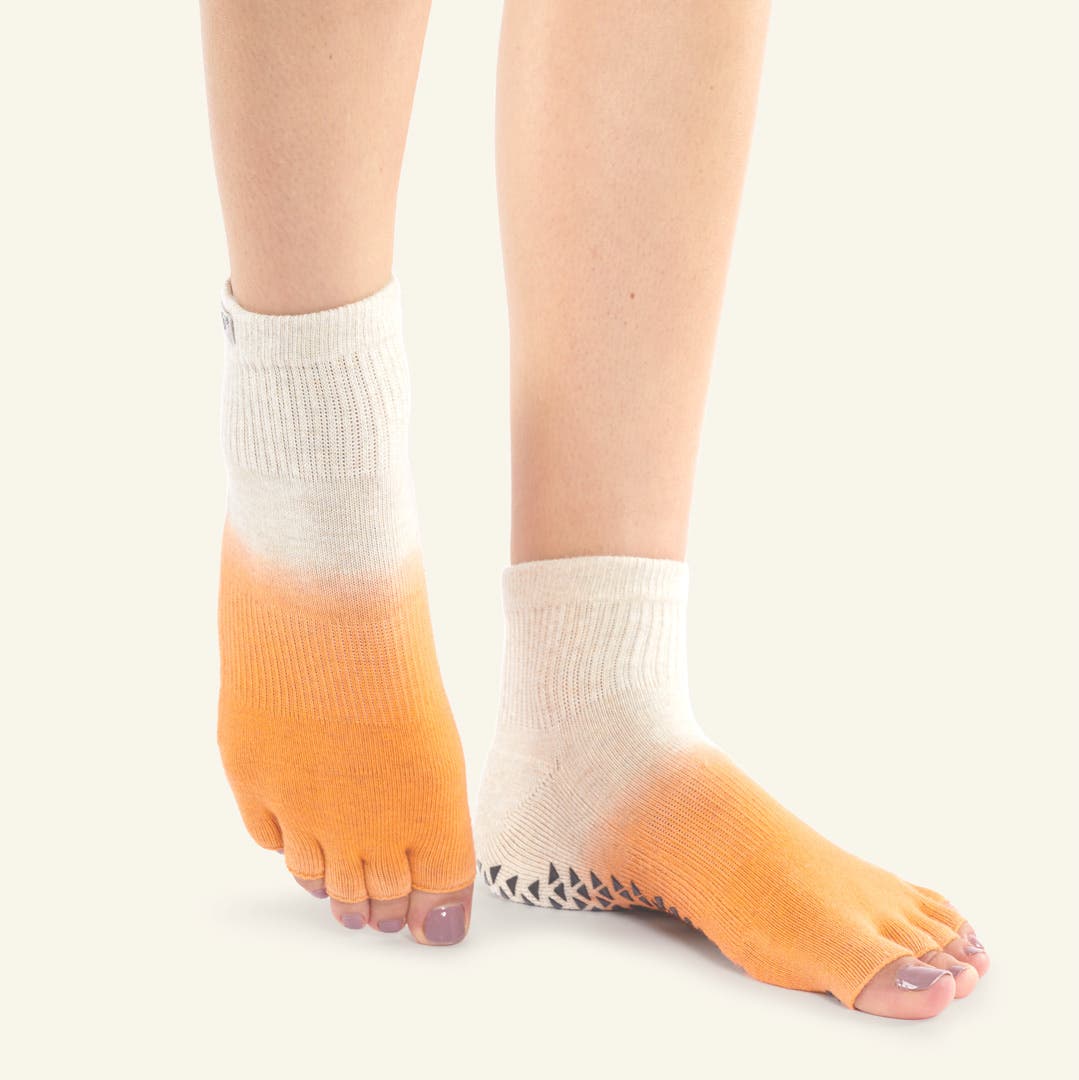 Closeup of someone pointing their toes wearing Injinji Grip Toeless Mini-Crew socks.