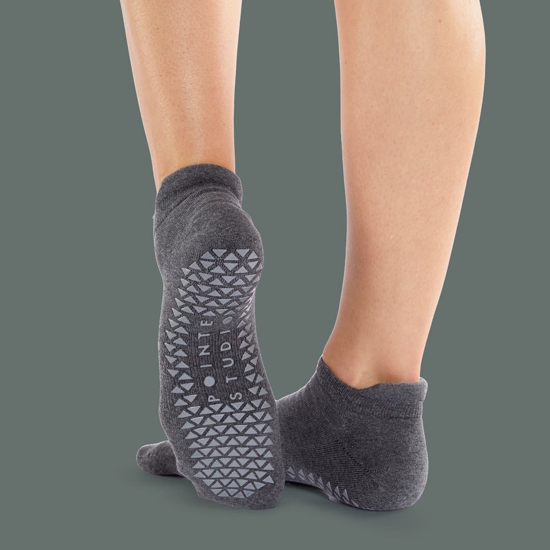 Closeup of someone pointing their foot wearing Injinji Grip Full Foot No-Show socks.