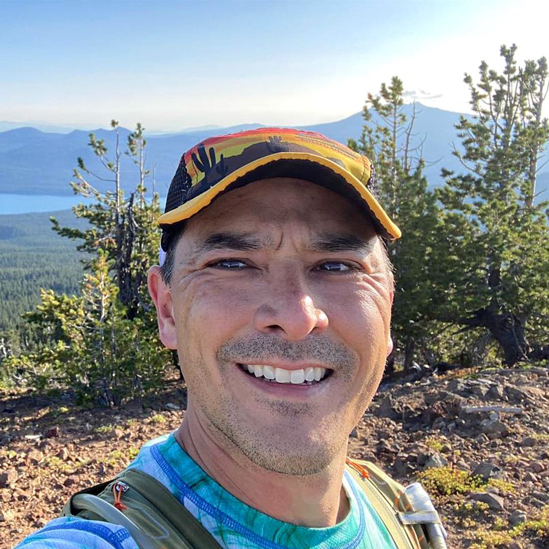 A selfie of Team Inijnji Athlete Trevor Davenport smiling on a trail.