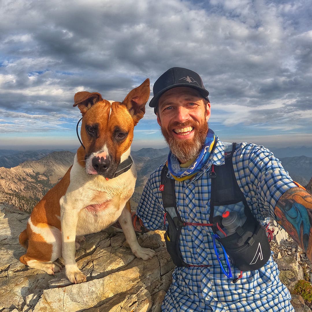 Garrick Arends taking a selfie with his dog Olly at the top of a summit.