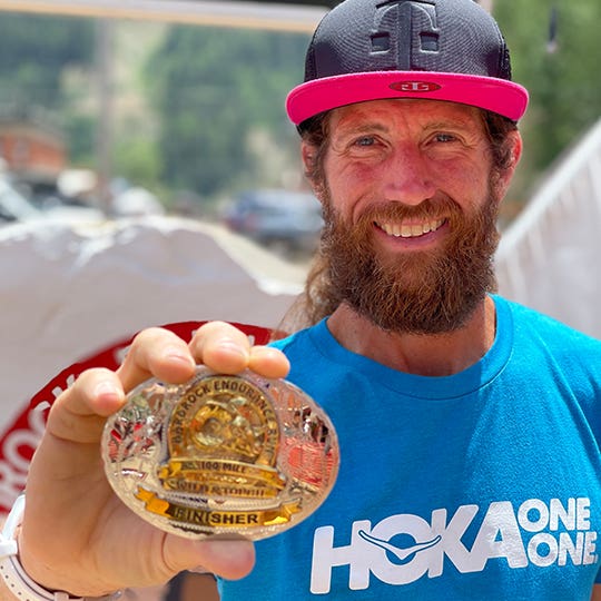 Mike Wardian Holding Up His Hardrock 100 Finisher's Belt Buckle Mike Wardian Holding Up His Hardrock 100 Finisher's Belt Buckle