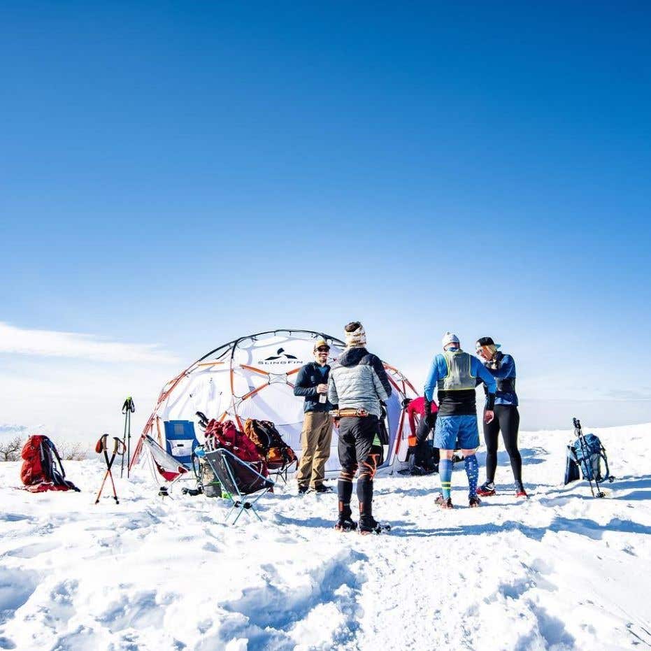 A runner getting help from their crew during the Malan Peak race in snowy Northern Utah.