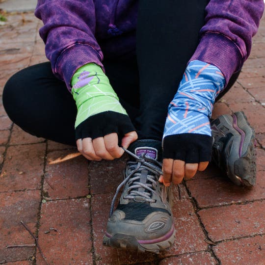 A person tying their running shoes wearing fingerless gloves made from Injinji toesocks.