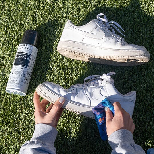 A person shining their sneakers with a shine product and an Injinji sock as a fabric buffer.