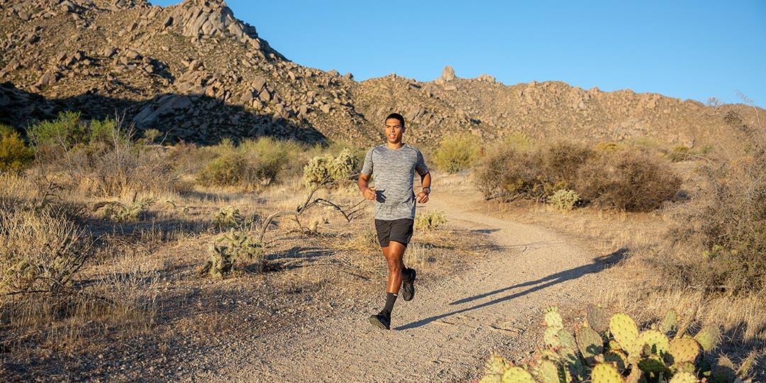 A runner mid stride on a desert trail.