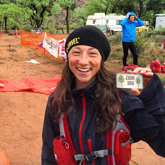 Jade Belzberg smiling at the camera and holding up her Zion 100 plaque